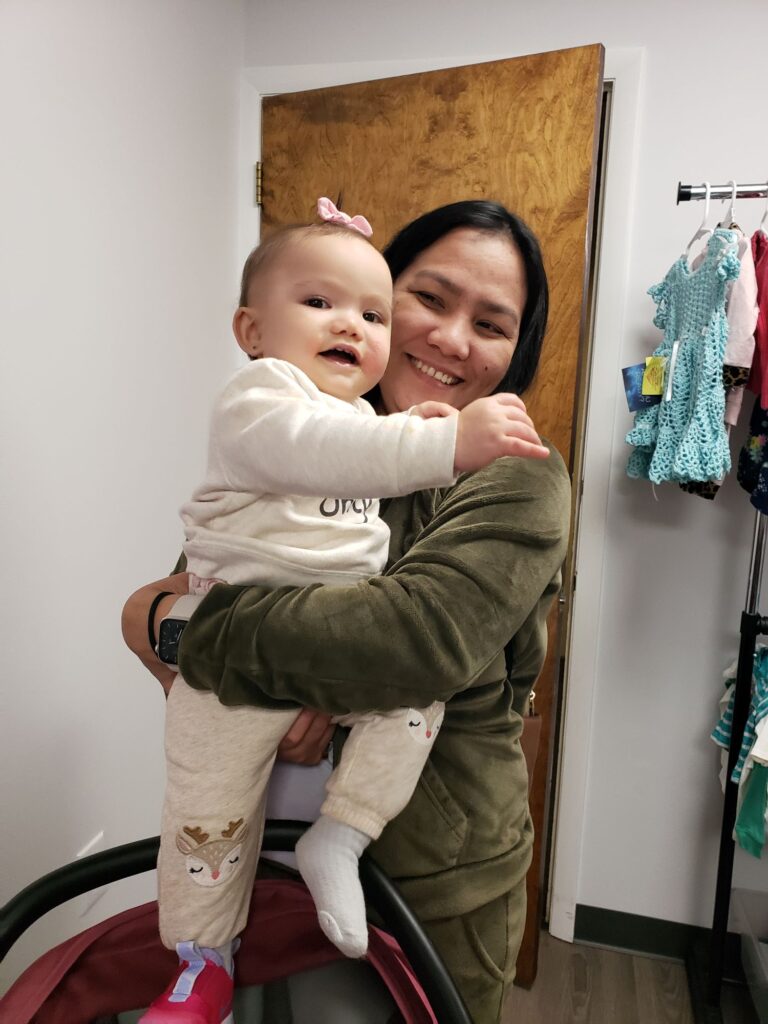 A smiling mother holds her smiling baby at Bright Hope Pregnancy Support Centers.