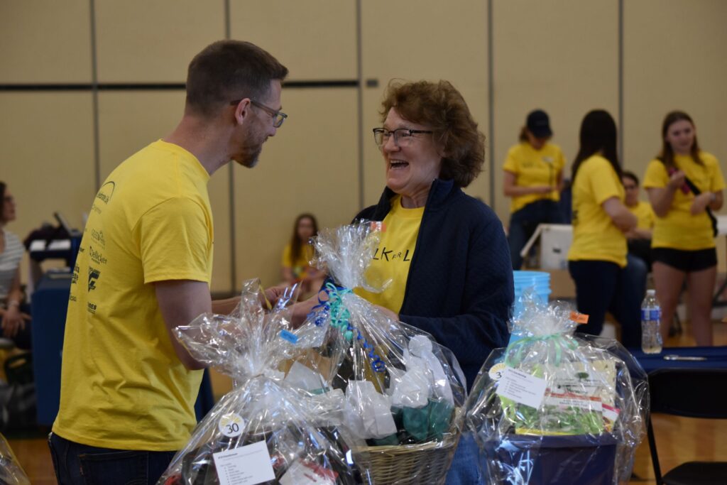 Claire Fopeano shares a smile with Adam Weiss after winning one of the prizes in the basket raffle inside the Charles Chrin Community Center during the 2026 Lehigh Valley Walk for Life held by Bright Hope Centers in Easton, Pennsylvania.