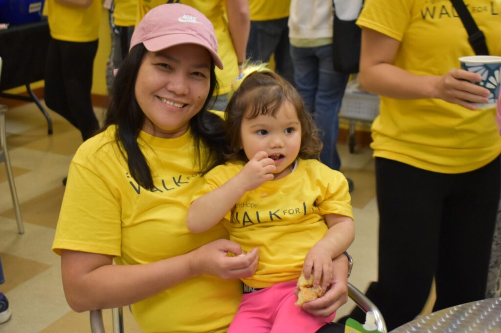 A young lady sits and has a little girl on her leg inside the Charles Chrin Community Center during the 2026 Lehigh Valley Walk for Life held by Bright Hope Centers in Easton, Pennsylvania.